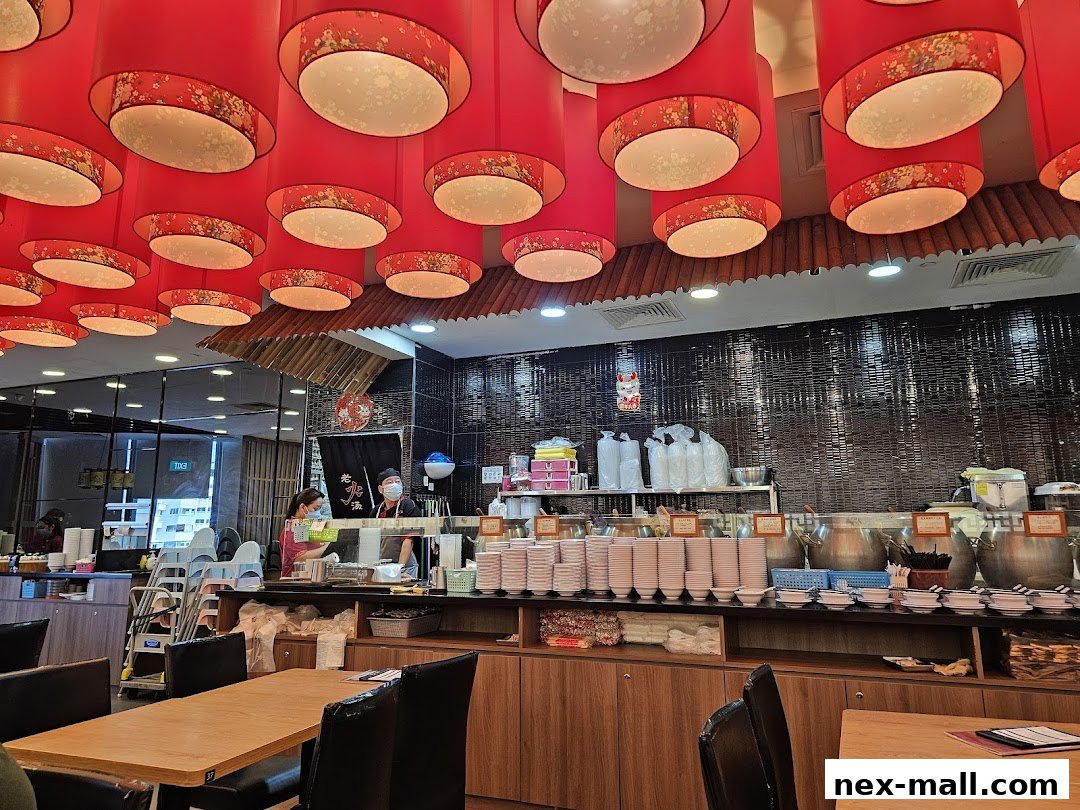 Interior of a restaurant with red lanterns, serving counter, and dining tables.