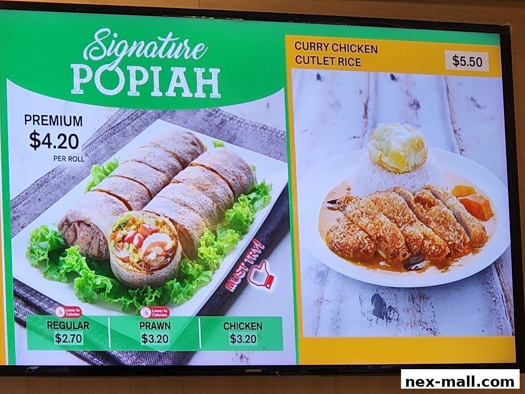 A digital menu board displaying Signature Popiah and Curry Chicken Cutlet Rice.