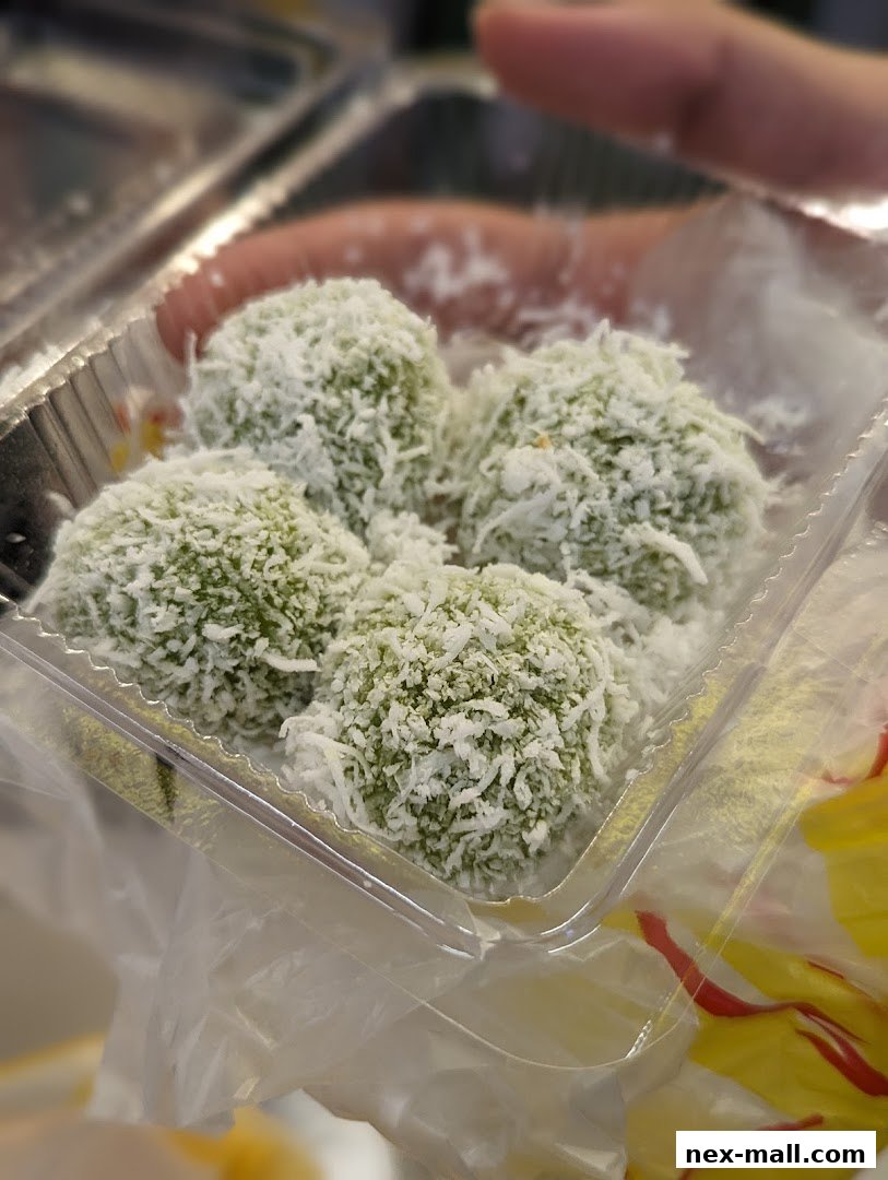 A close-up shot of Onde-onde, a traditional Indonesian dessert, covered in shredded coconut.