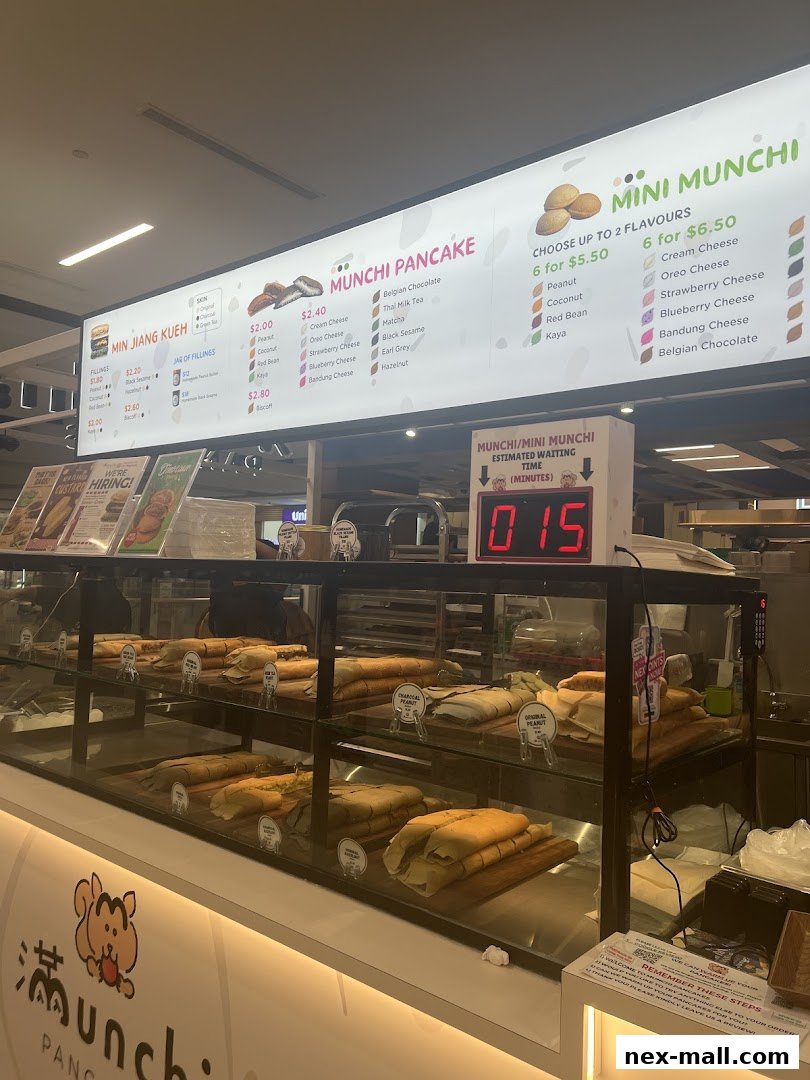 A display counter filled with freshly made pancakes and a menu board above.