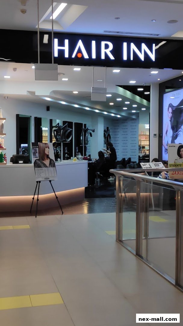 The entrance to Hair Inn, a modern hair salon with a bright sign and stylish interior.