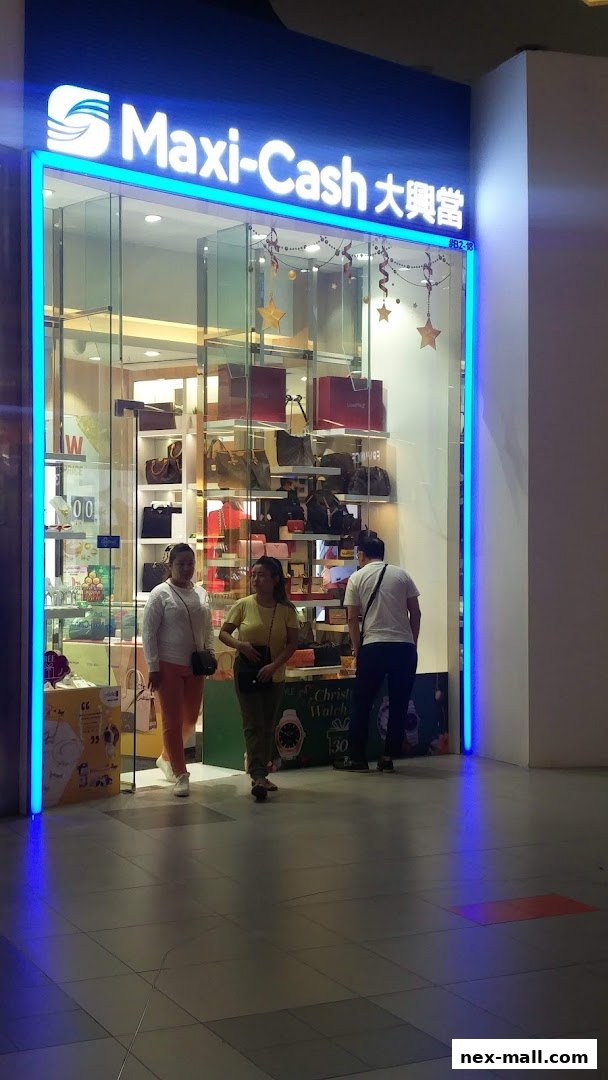 The brightly lit entrance of Maxi-Cash NEX Serangoon, showcasing various bags and accessories on display.