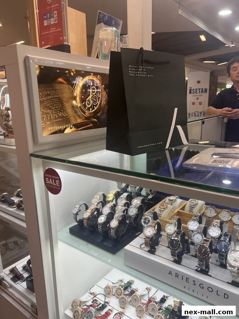 A display case filled with various watches, with a shopping bag and a promotional sign.