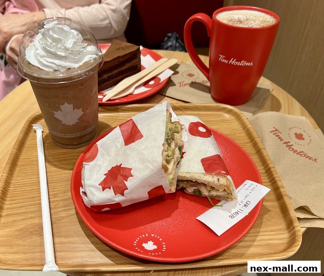 A tray of Tim Hortons food including a sandwich, a chocolate cake slice, and a coffee drink.