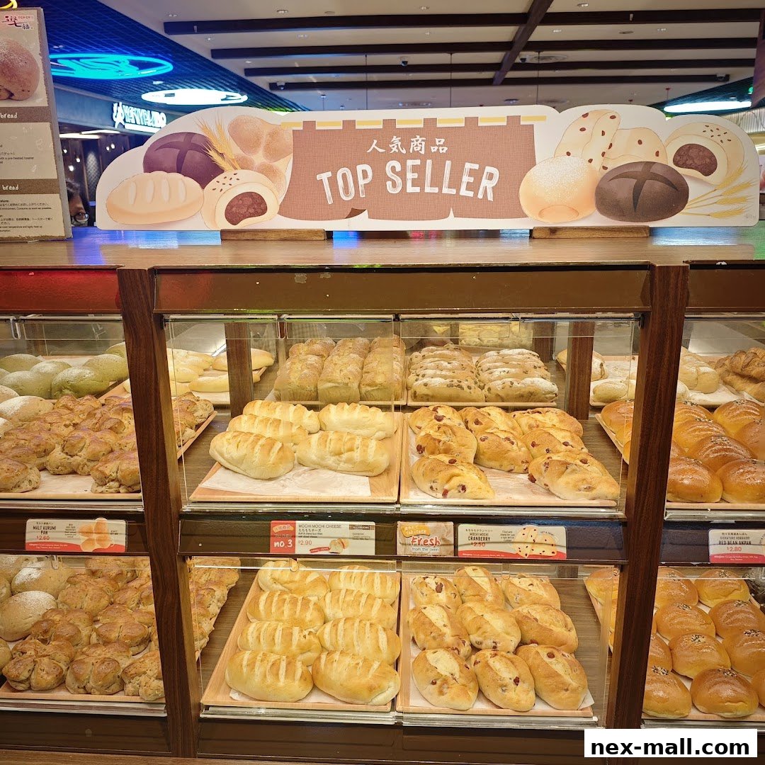 A display of various freshly baked breads and pastries in a shop.