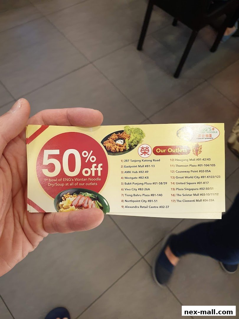 A hand holds a promotional card offering 50% off the first bowl of Wantan Noodle.
