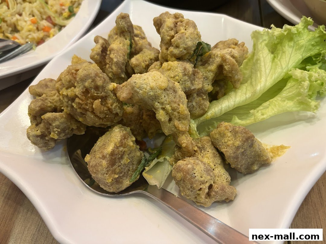 A plate of golden fried chicken pieces with lettuce garnish, served with a spoon.