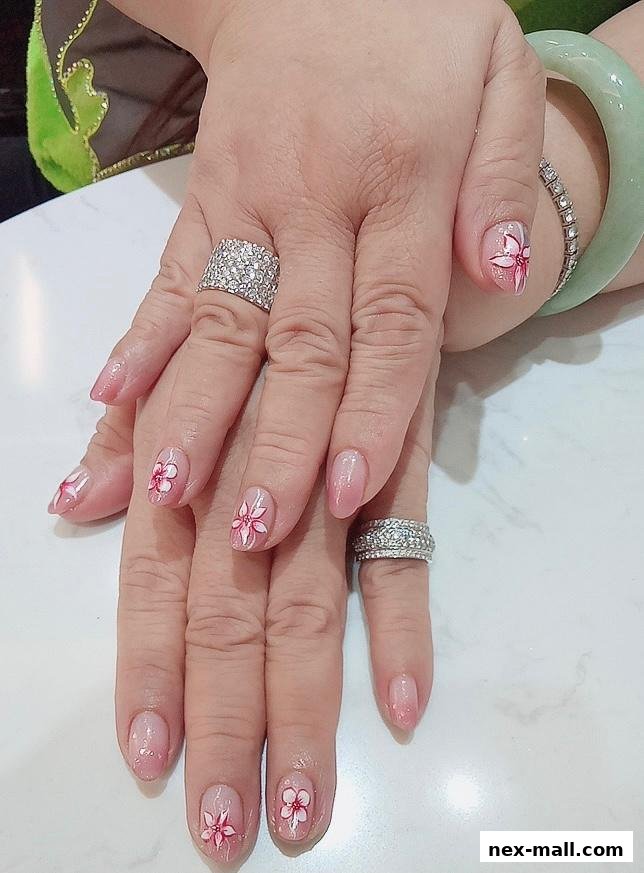 Close-up of hands with delicate floral nail art and sparkling rings.