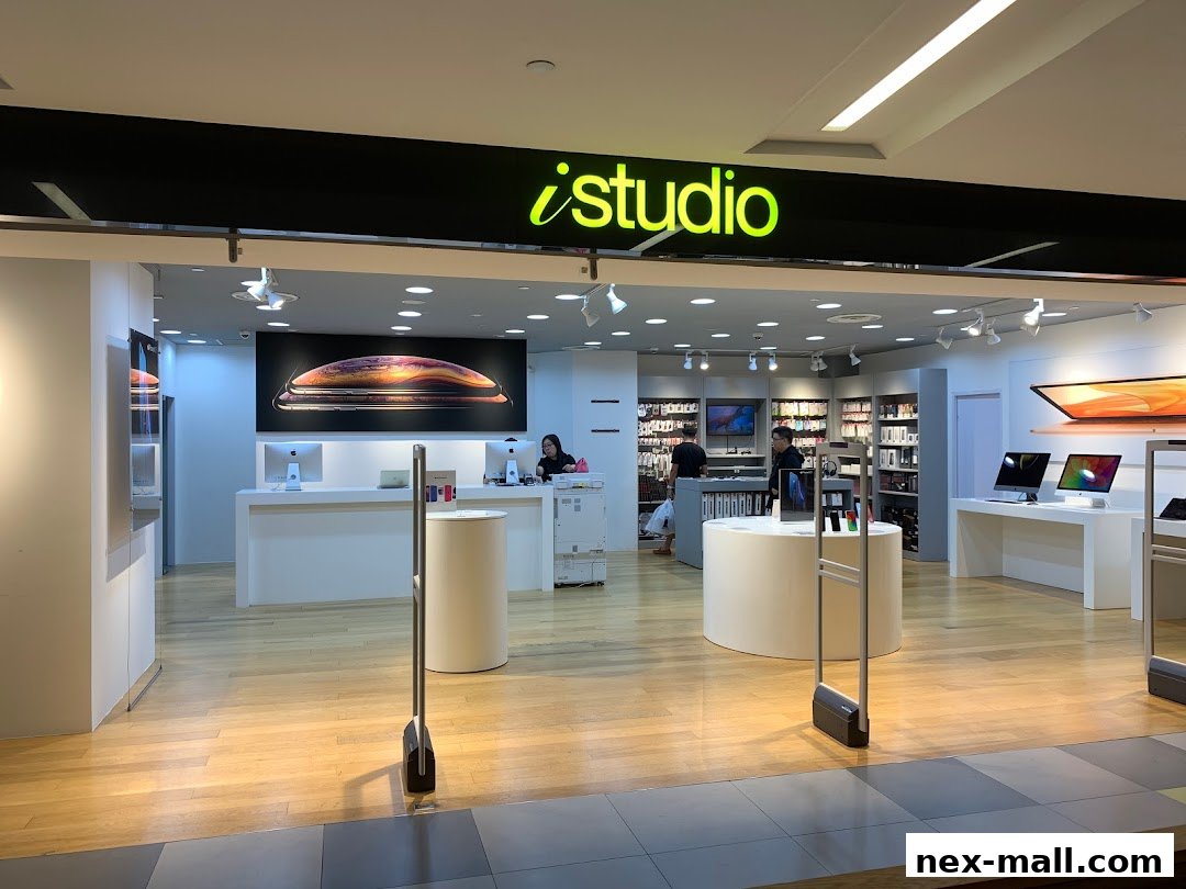 The entrance of an iStudio store showcasing Apple products and a sleek, modern interior.