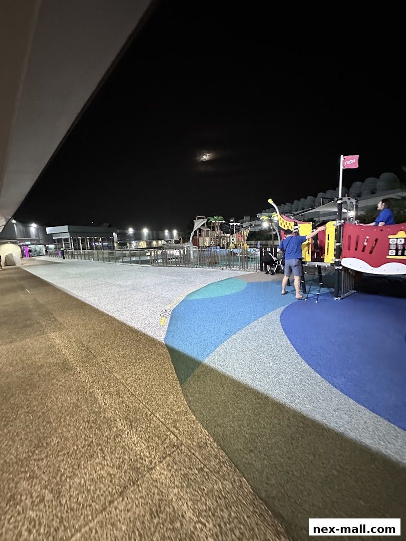 A playground area with colorful flooring and play structures at night.