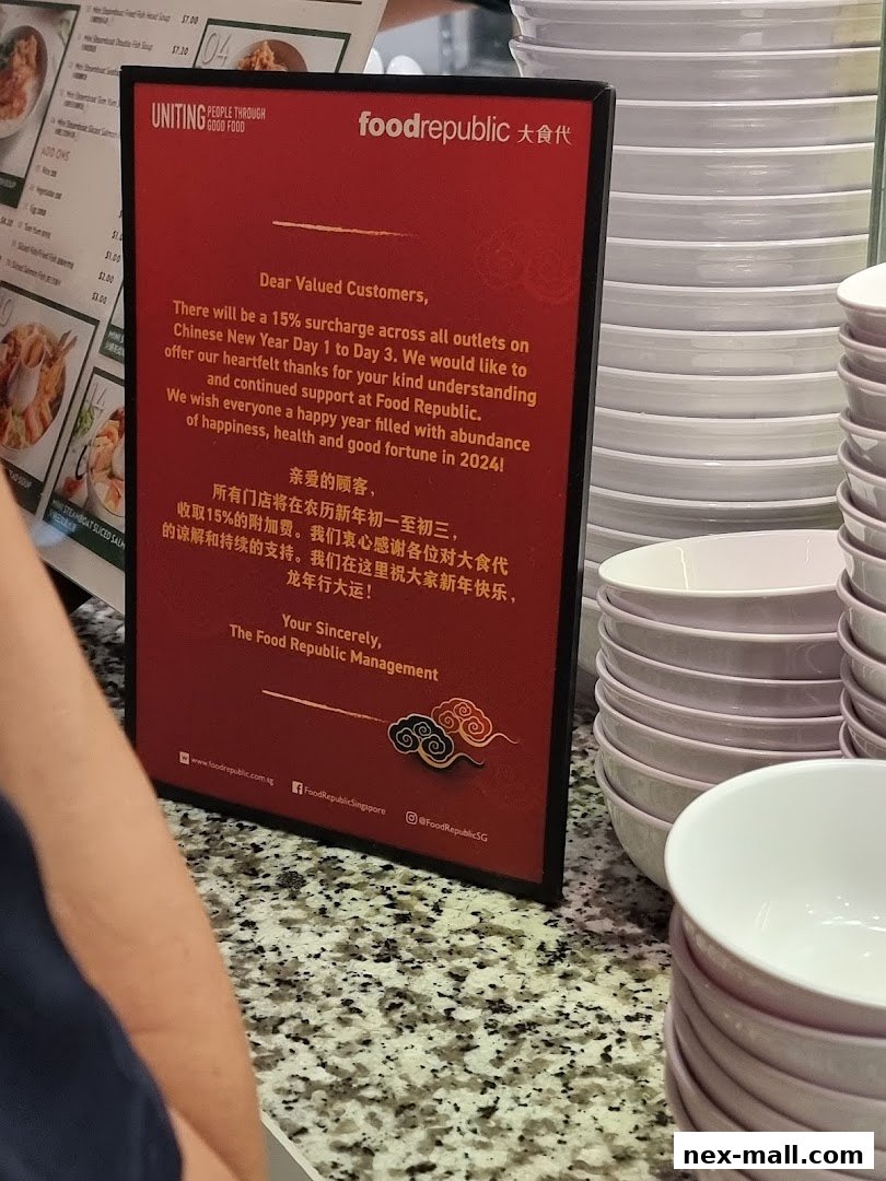 A red sign from Food Republic announcing a surcharge for Chinese New Year and wishing customers a happy new year.