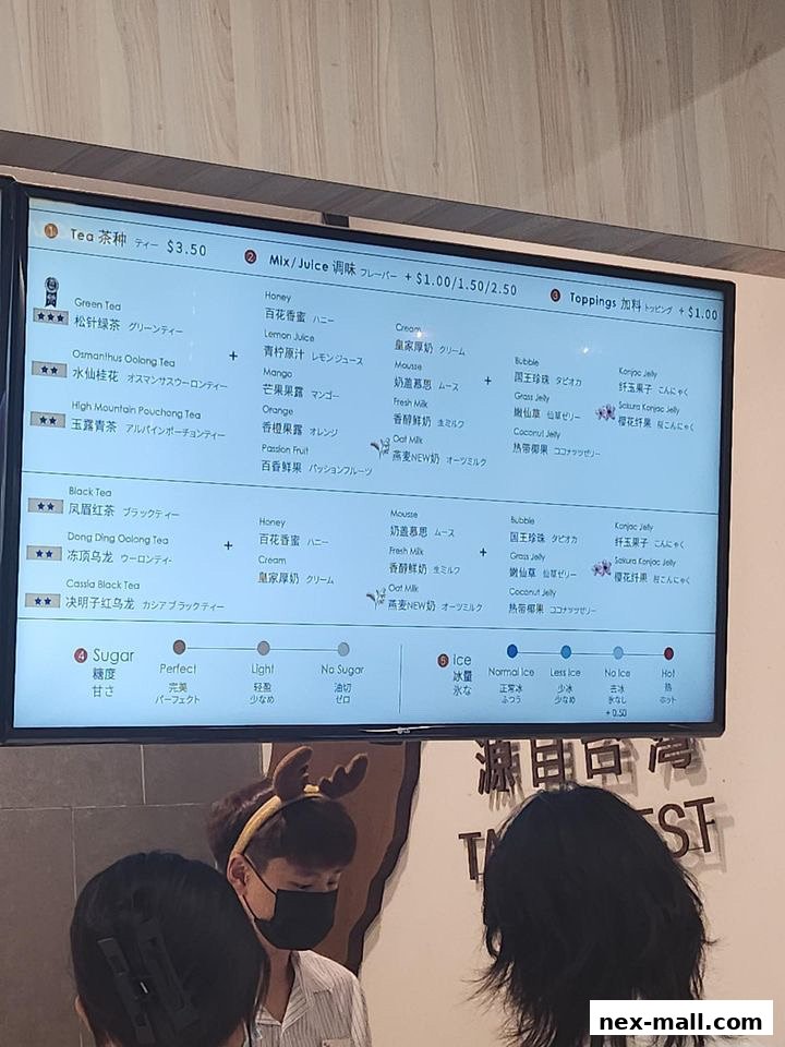 A digital menu board displaying various tea options, flavors, toppings, and sugar/ice preferences.