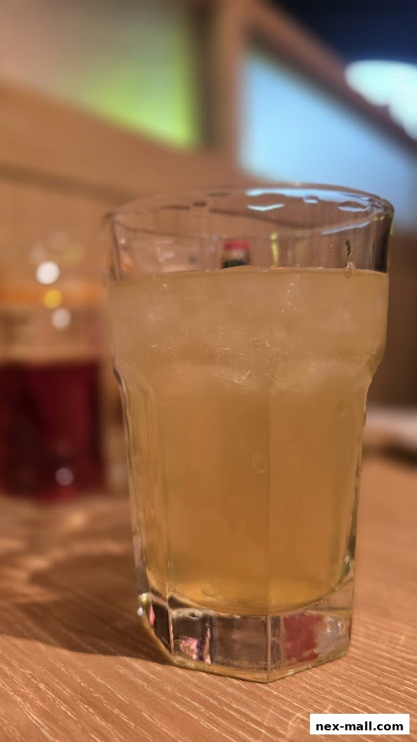 A close-up of a refreshing iced beverage in a glass, with another drink in the background.