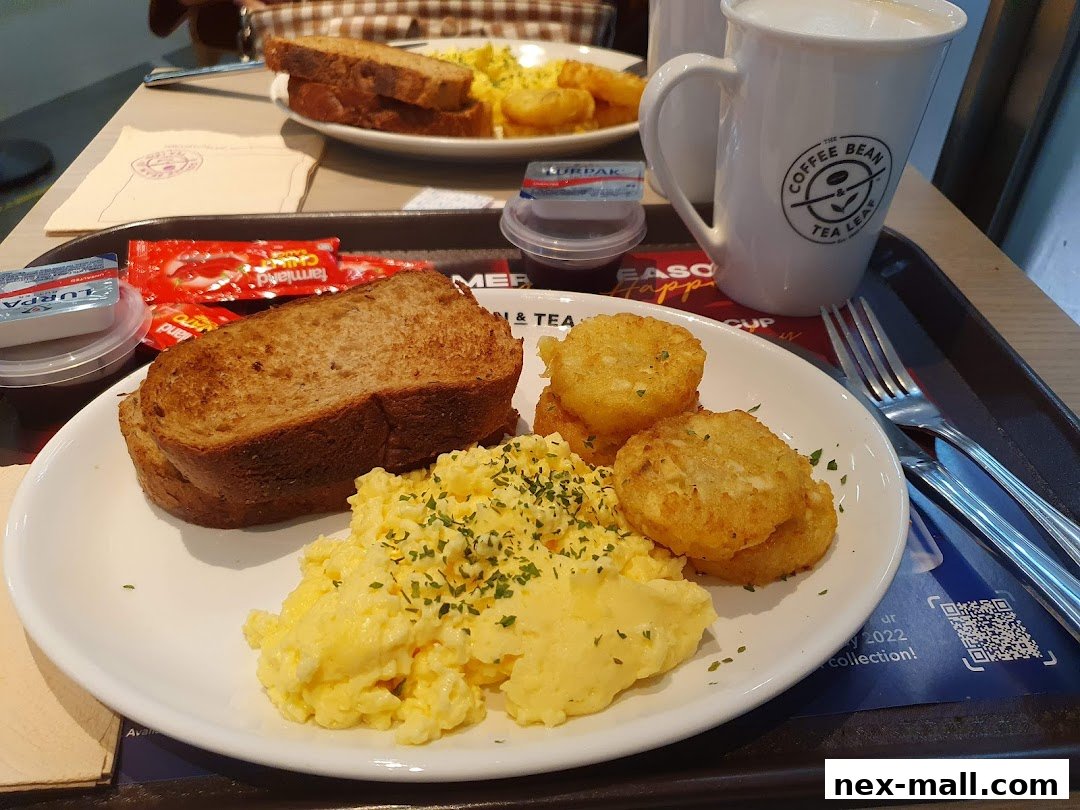 A breakfast plate with scrambled eggs, hash browns, and toast, served with a coffee mug.