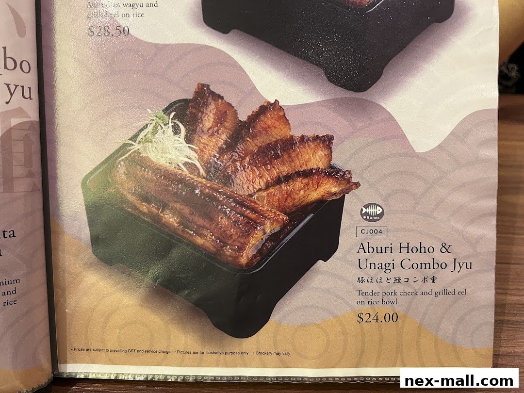 A close-up of a menu item featuring grilled eel and pork cheek on a rice bowl.