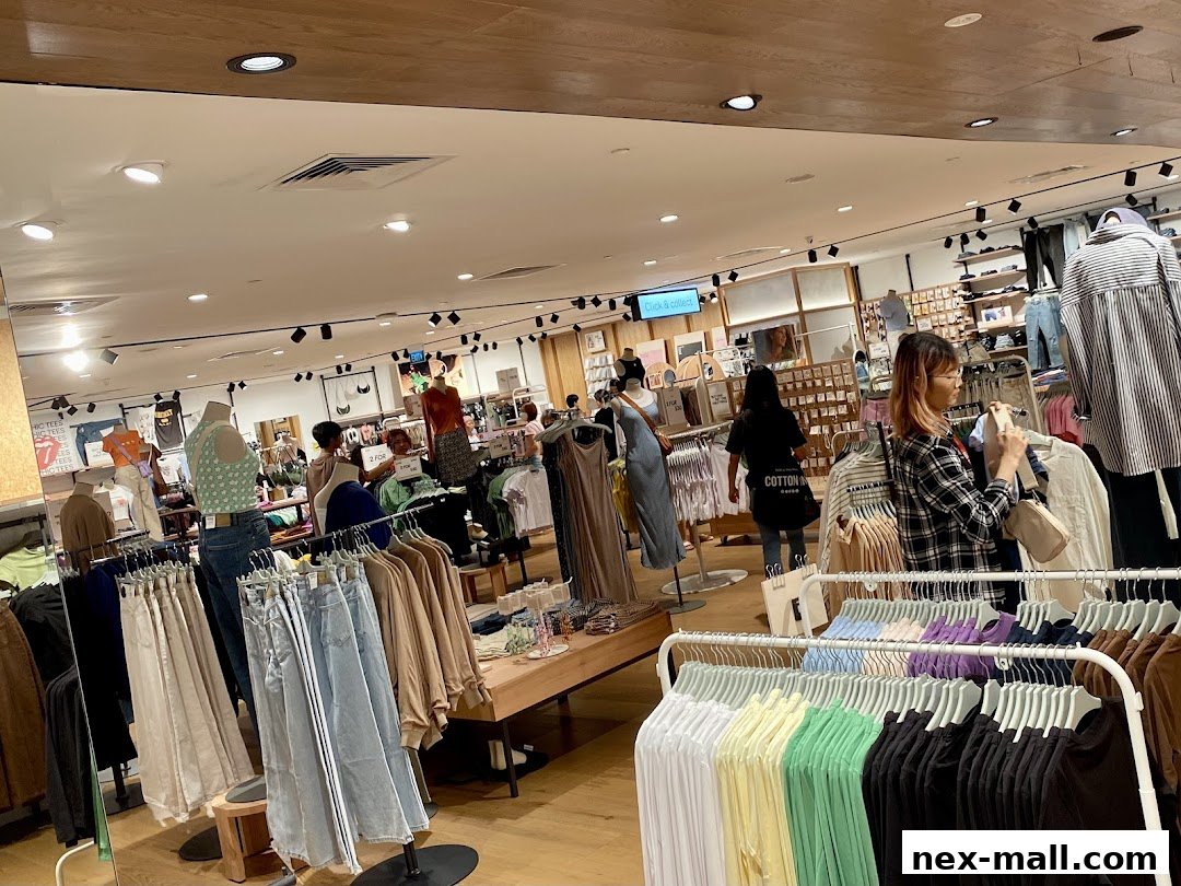 Interior view of a Cotton On store with clothing racks and shoppers.