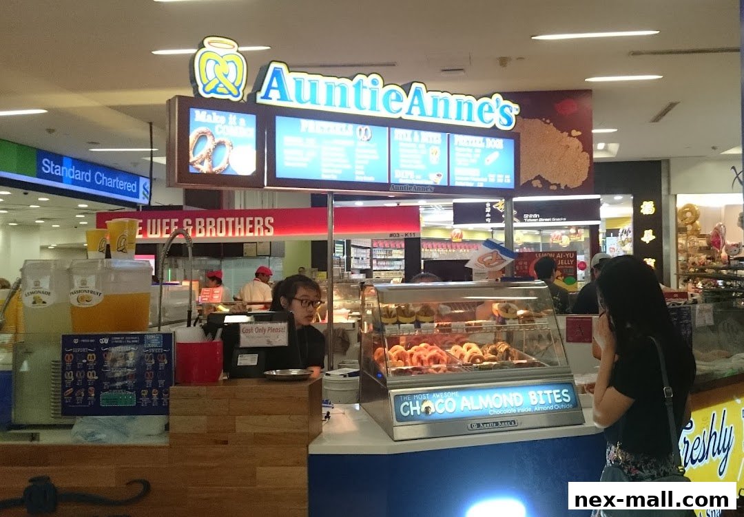 Auntie Anne's pretzel shop counter with pretzels, drinks, and a customer.