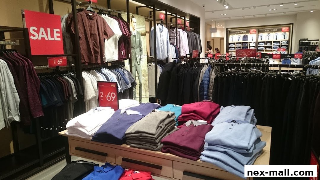 Interior view of a G2000 clothing store with racks of shirts and sale signs.