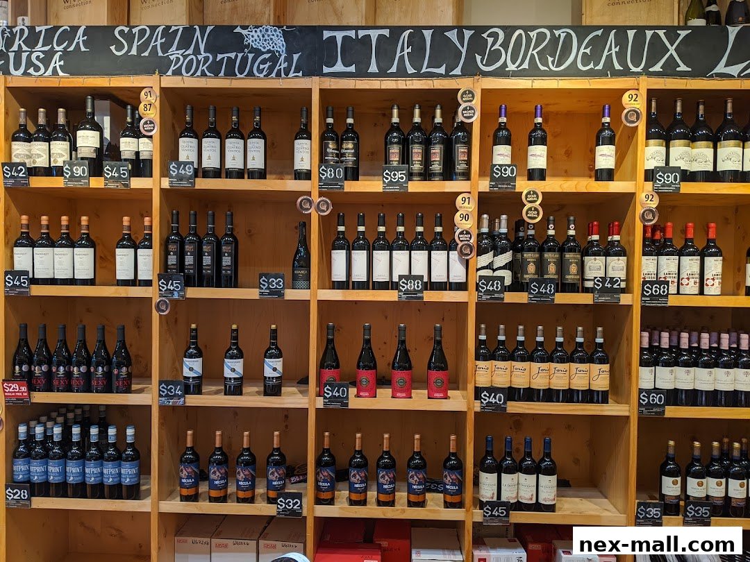 Shelves stocked with various bottles of wine, categorized by region and price.