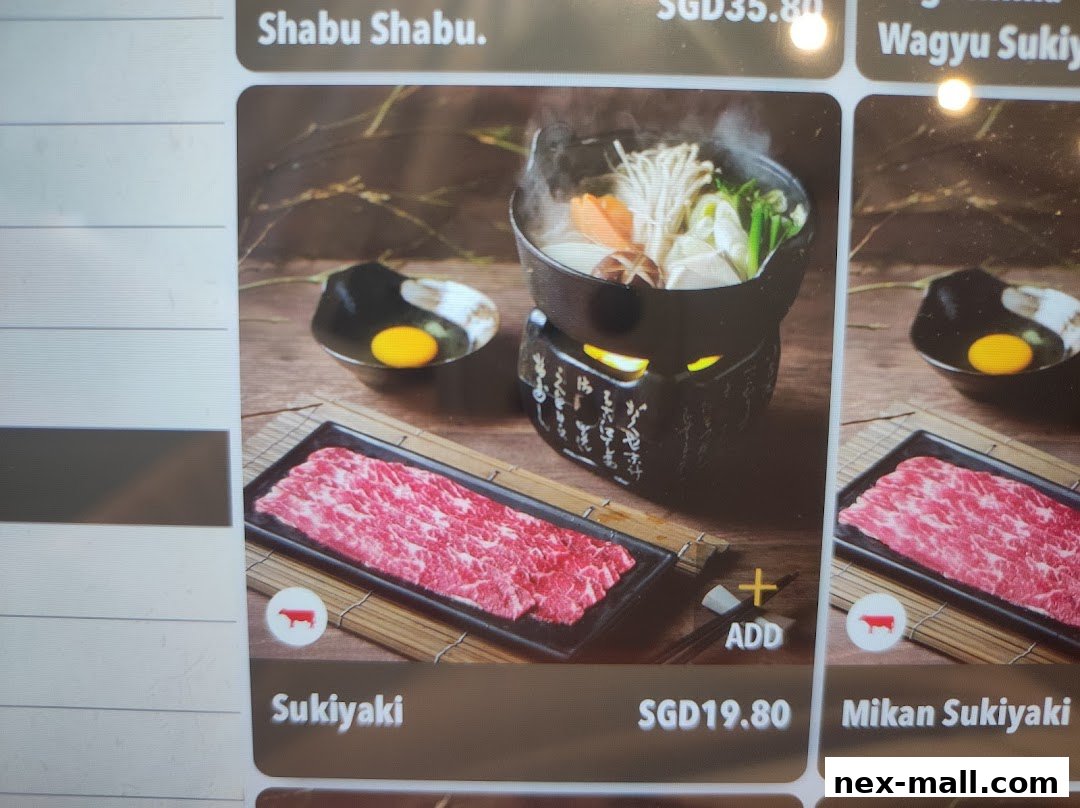 A close-up of a menu item featuring thinly sliced beef for Sukiyaki with a hot pot.