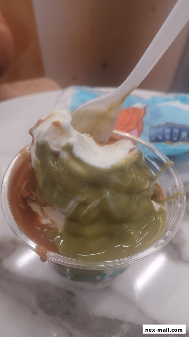 A close-up of a delicious soft-serve ice cream with chocolate and matcha flavors.