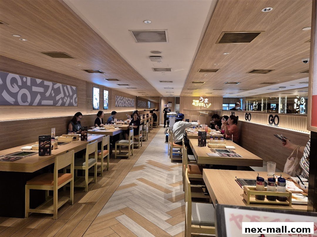 Interior view of a busy Yakiniku-GO NEX restaurant with diners seated at tables.