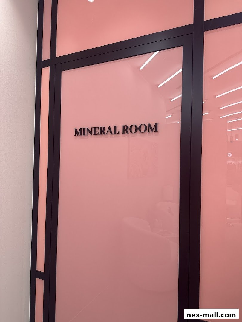 A frosted pink glass door with black framing, displaying the text 'MINERAL ROOM'.