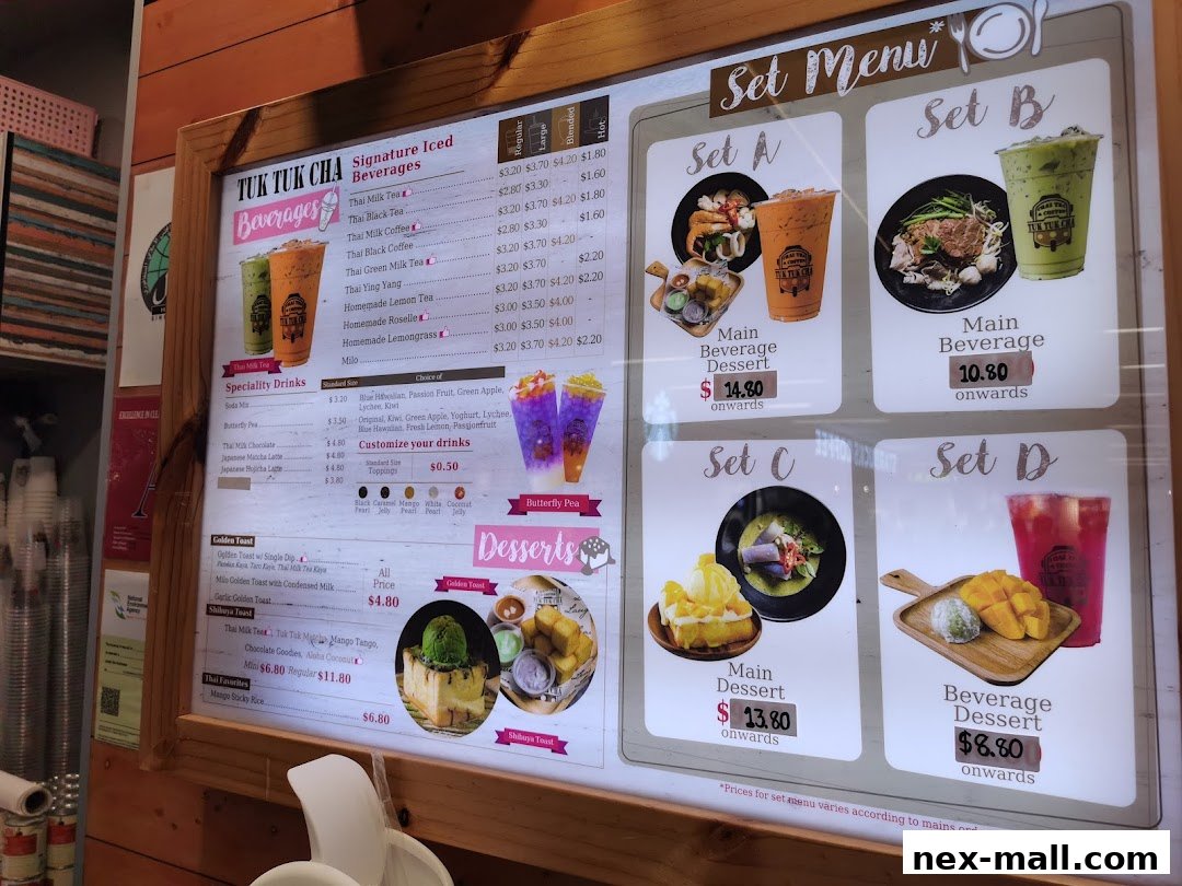 A menu board displaying signature iced beverages, specialty drinks, set menus, and desserts from Tuk Tuk Cha.