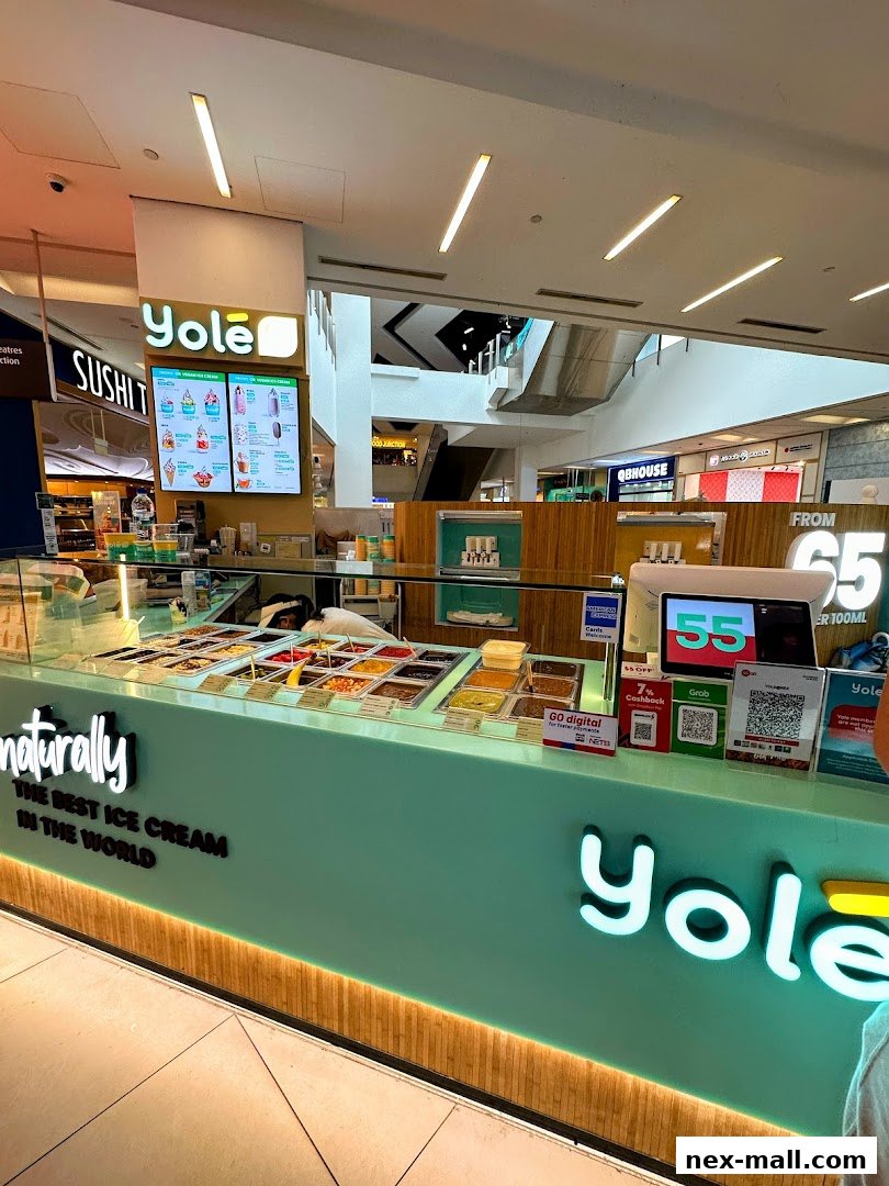 A Yolé ice cream shop counter with various toppings and a digital display.