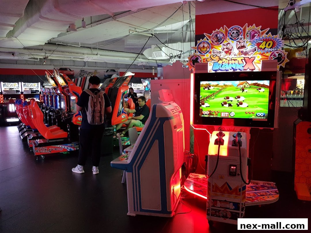 Interior of an arcade with rows of racing game machines and a shooting game.