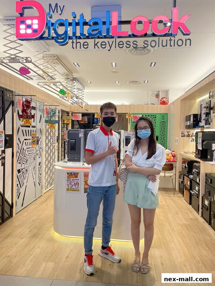 Two people stand in front of a brightly lit shop with digital locks and security solutions on display.
