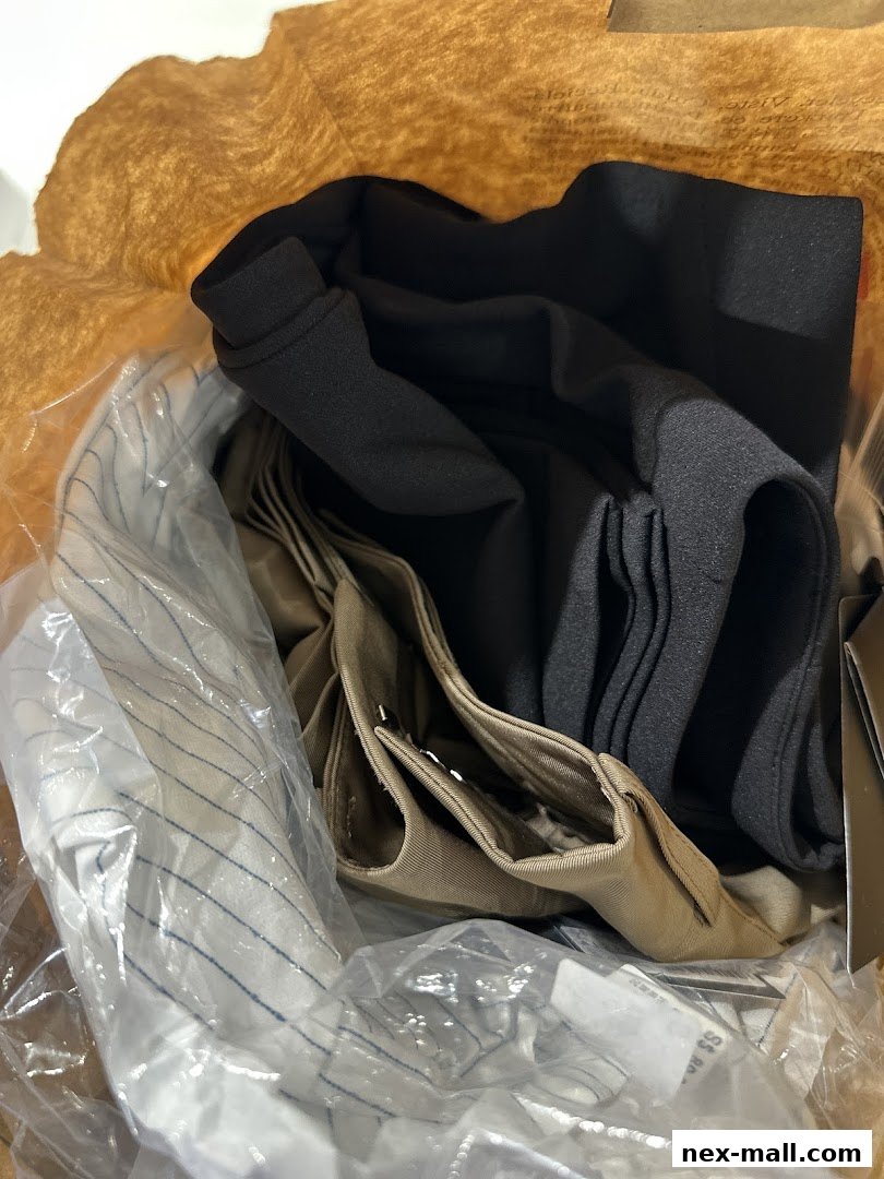 A close-up view of folded clothing items, including striped fabric and solid black and tan garments.
