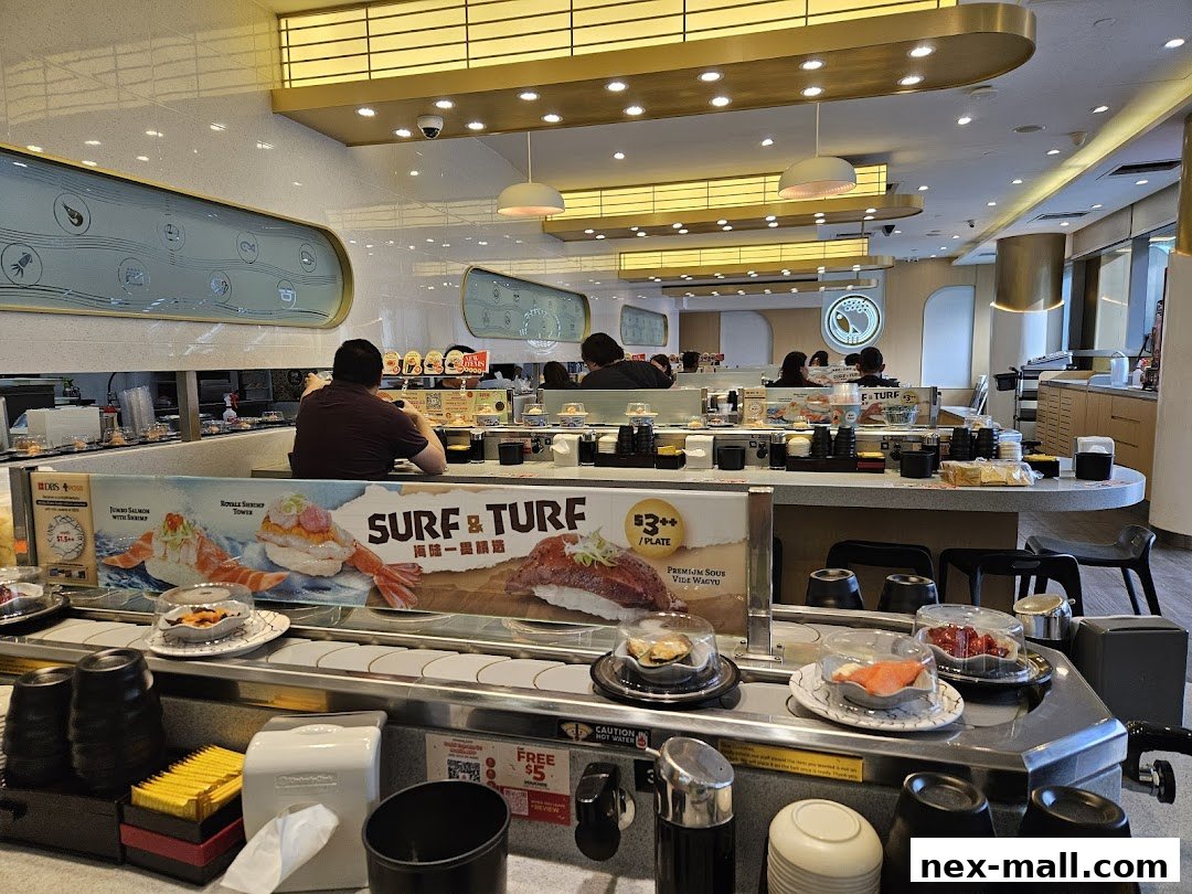 Interior of a sushi restaurant with a conveyor belt displaying various sushi dishes.