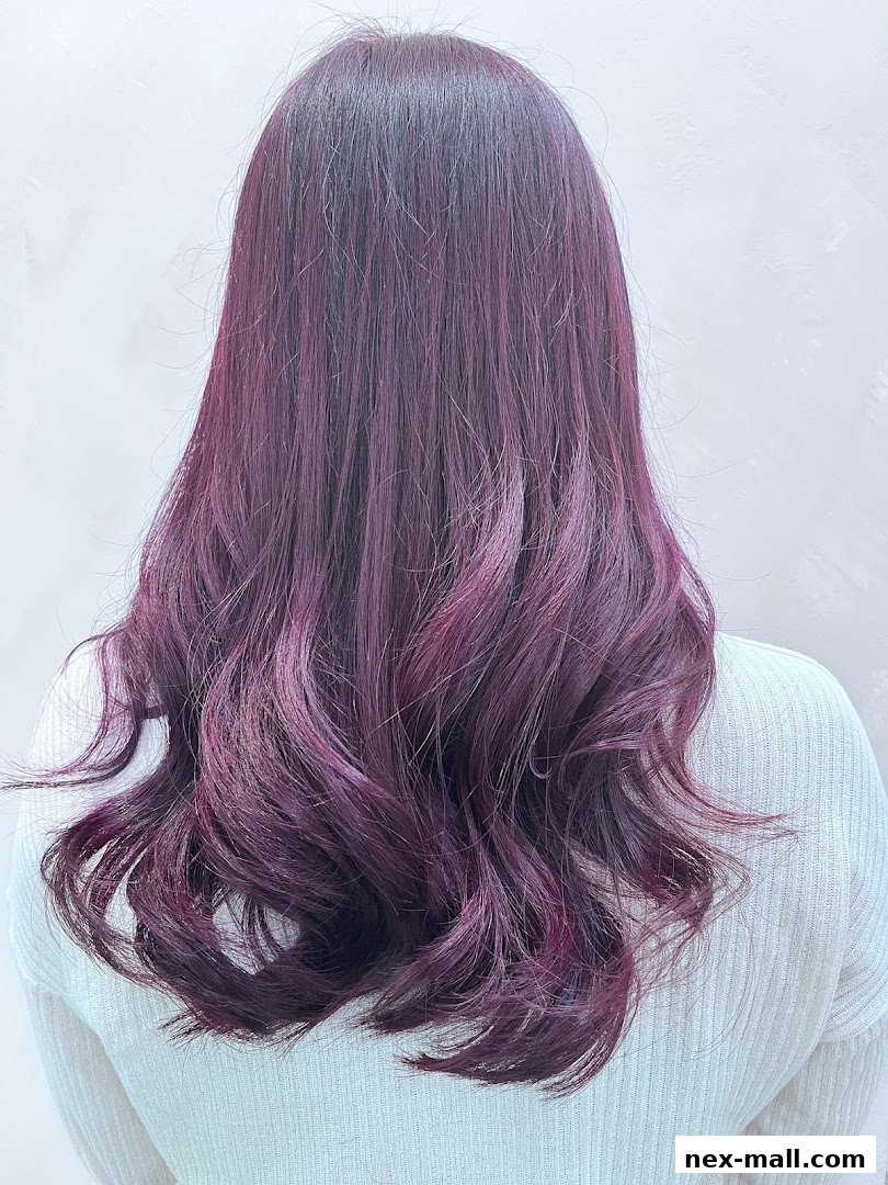 A person's back showcasing beautifully styled, wavy hair with a rich plum and magenta color.