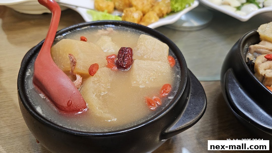A close-up of a steaming bowl of nourishing soup with winter melon and goji berries.