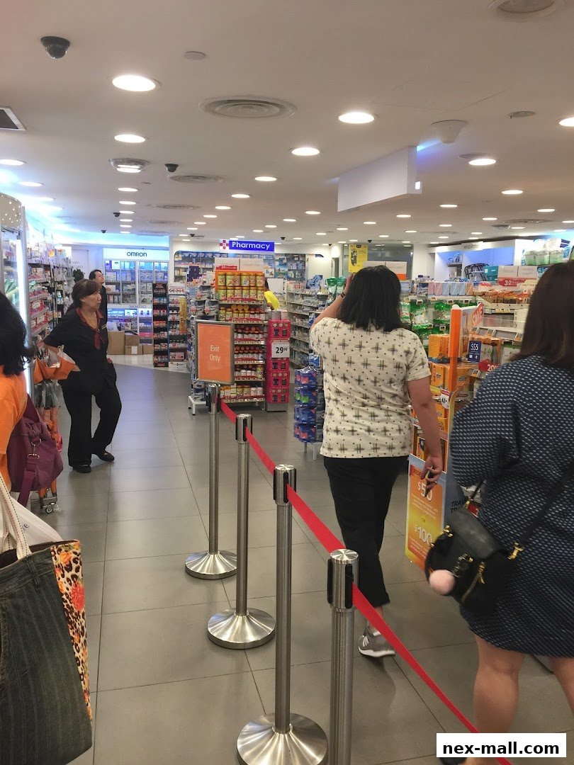 Customers queue inside a Guardian pharmacy with shelves stocked with health and beauty products.