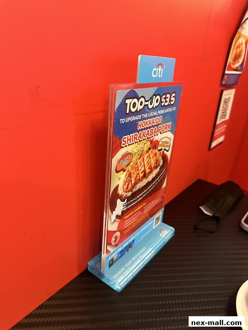 A promotional stand for a Hokkaido Shirakaba Pork upgrade at Monster Curry.