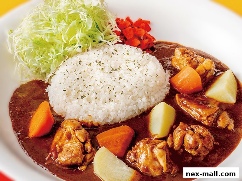 A delicious plate of Japanese curry with rice, chicken, potatoes, carrots, and shredded cabbage.