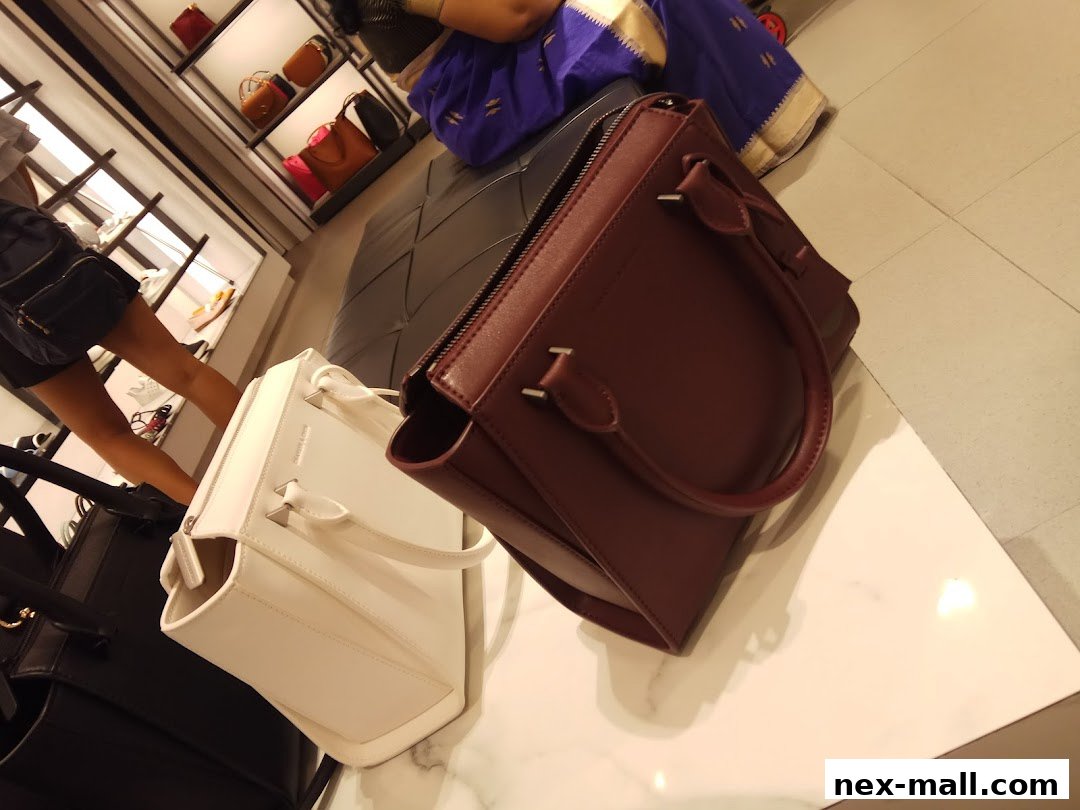 Stylish handbags displayed on a marble surface in a retail store.