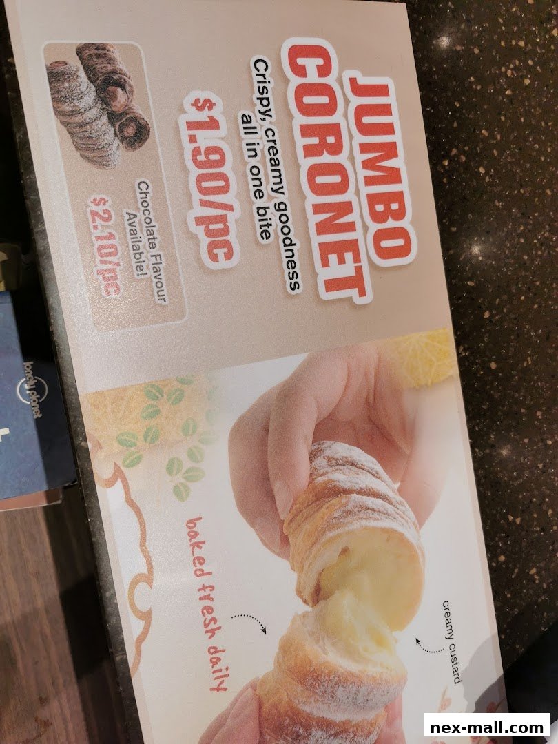 A close-up of a Jumbo Coronet pastry with creamy custard filling.