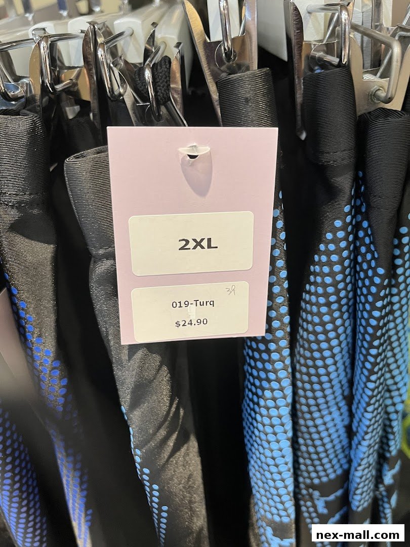 Close-up of clothing with size and price tags, showing a blue dotted pattern.