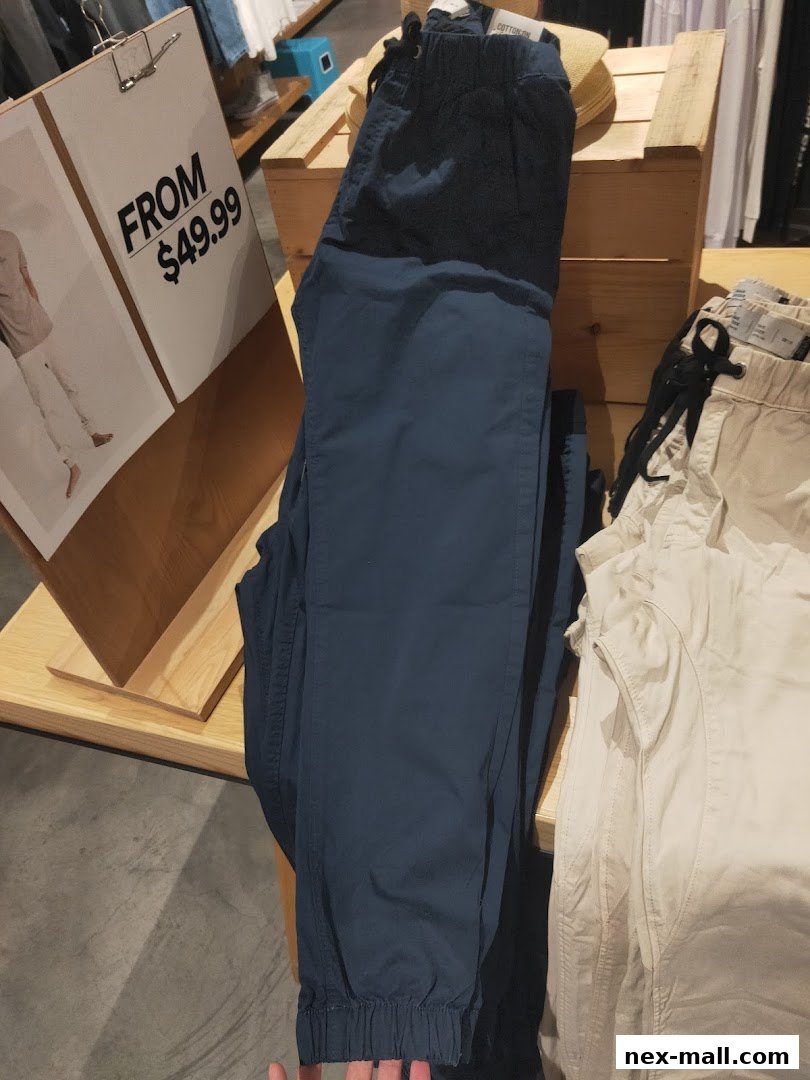 A display of navy blue and beige pants with a sign indicating prices starting from $49.99.