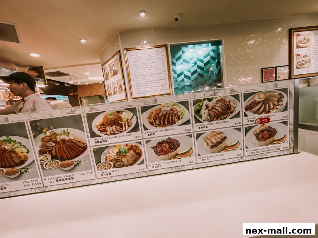 A display of various duck and meat dishes with prices at Food Junction.