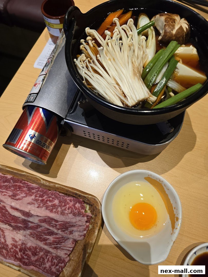 A close-up of a Japanese hot pot dish with thinly sliced beef, enoki mushrooms, and vegetables.