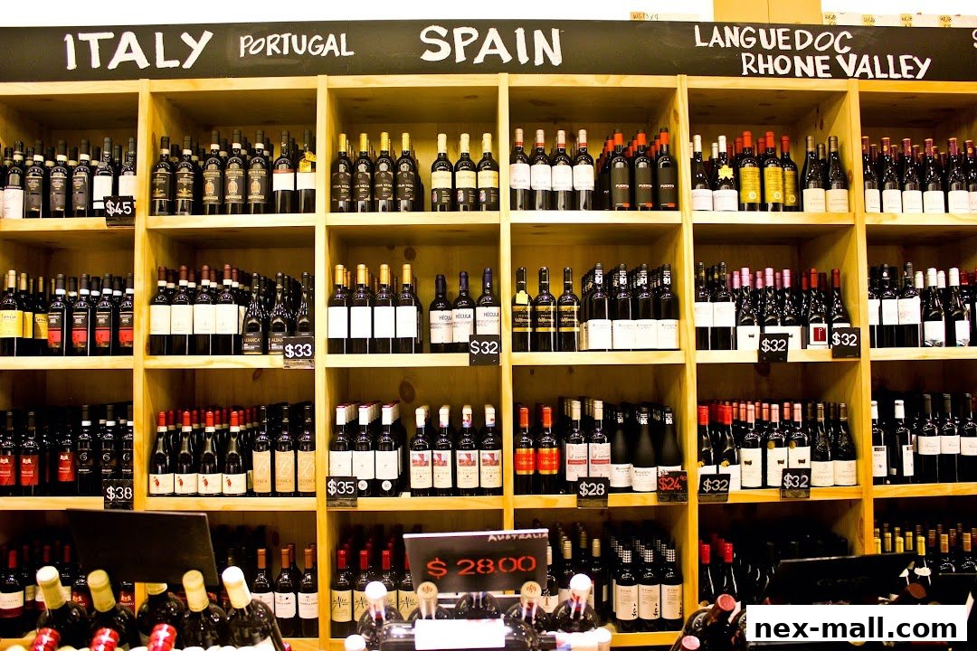 A wide selection of wine bottles displayed on shelves, categorized by country and region.