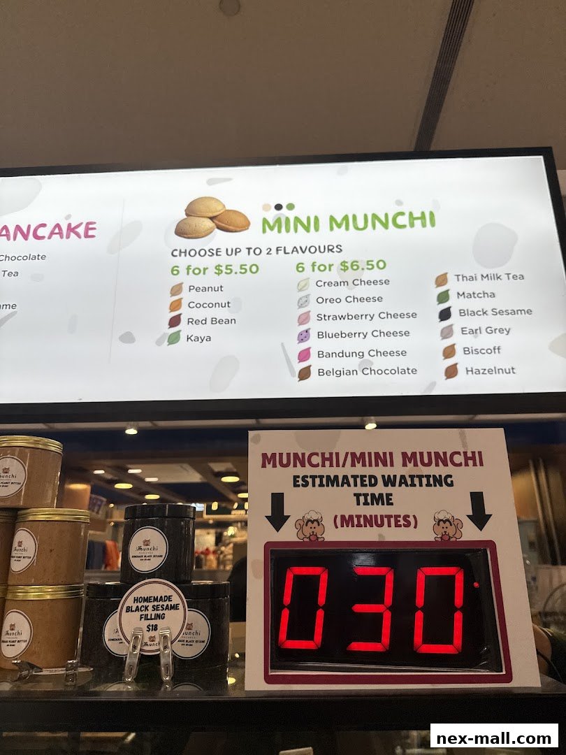 A menu board displaying mini pancakes with various flavors and an estimated waiting time display.
