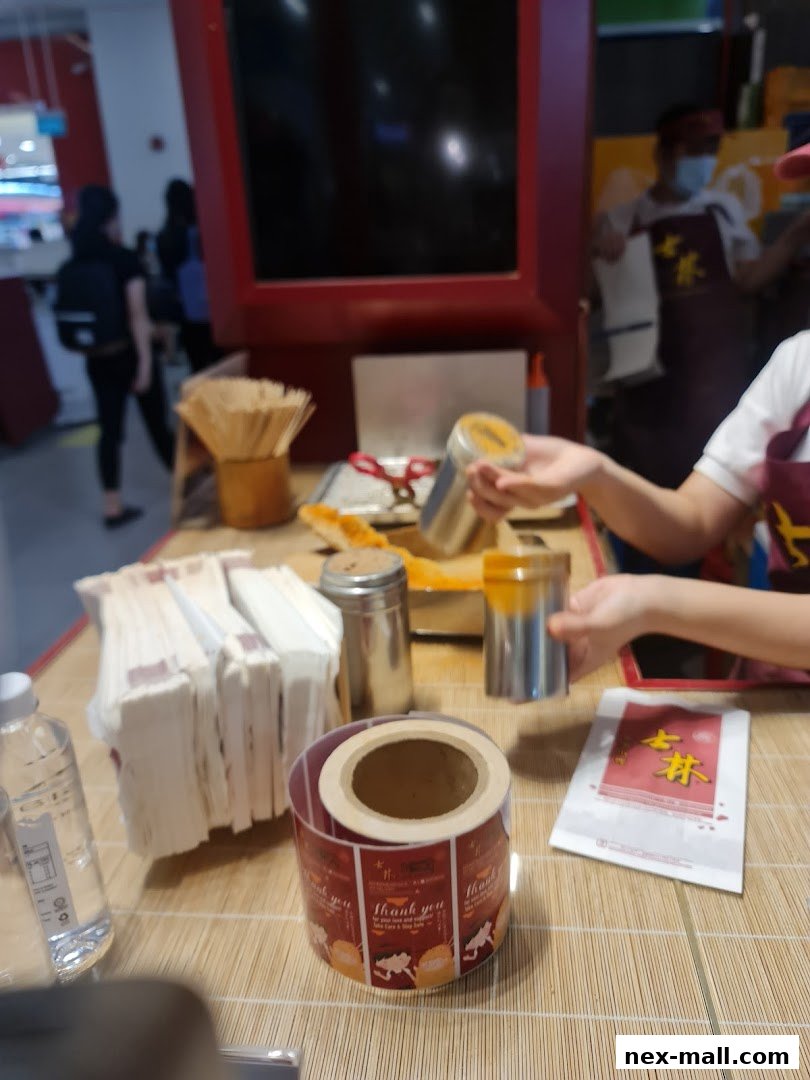A counter at Shihlin Taiwan Street Snacks with food preparation items and packaging.
