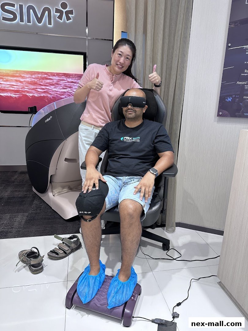 A woman gives a thumbs up next to a man trying out a massage chair and foot massager.