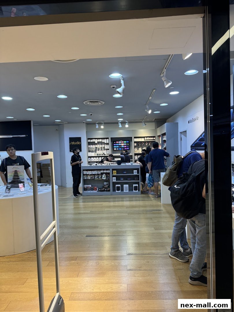 Interior view of an iStudio NEX electronics store with customers browsing products.