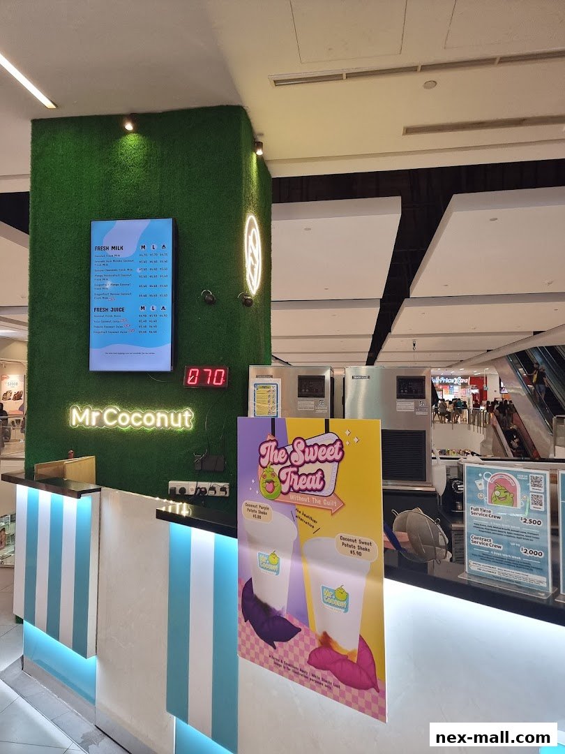The counter of Mr. Coconut NEX shop with a menu and promotional posters.